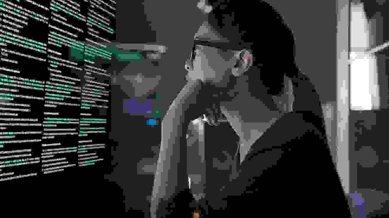 Woman reads computer screen in darkened lab